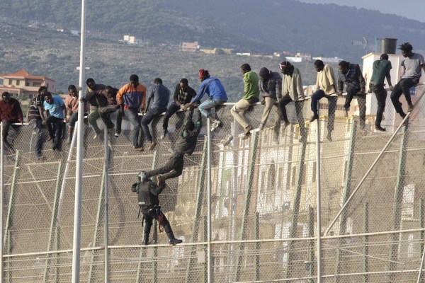 UN CENTENAR DE INMIGRANTES PERMANECEN ENCARAMADOS EN LA VALLA DE MELILLA